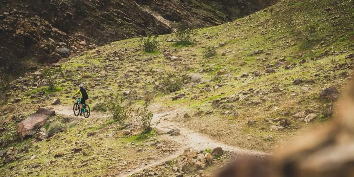 Mountainbiker auf einem steinigen Singletrail – hier wird das Fahrwerk gemessen, nicht auf dem Prüfstand