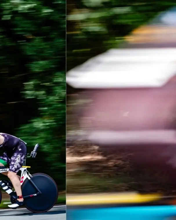 Triathlet auf dem Zeitfahrrad mit Scheibenrad, der Hintergrund verwischt vor Tempo